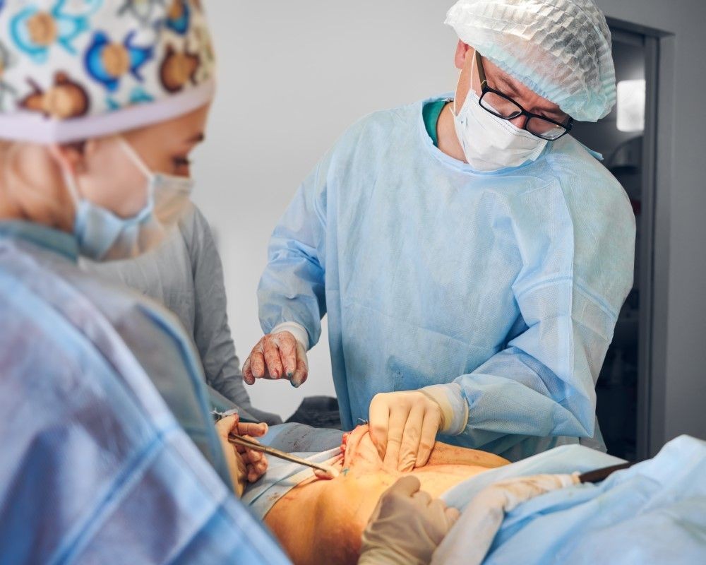 Equipo médico del Dr. Marco Aurelio Rendón realizando abdominoplastia bajo la dirección de un cirujano plástico certificado.