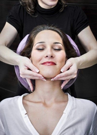 imagen de una paciente recostada en una camilla mientras la doctora toca su rostro resaltando los resultados logrados tras el procedimiento de rejuvenecimiento facial con piel más firme y luminosa